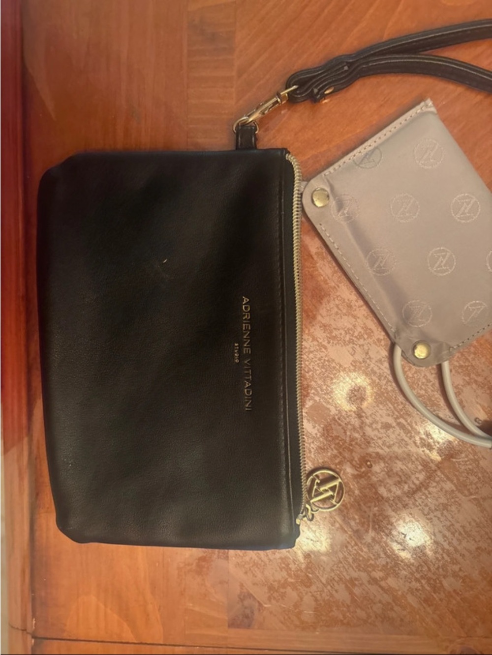 Adrienne Vittadini Black Leather Wristlet with phone charger pack connected